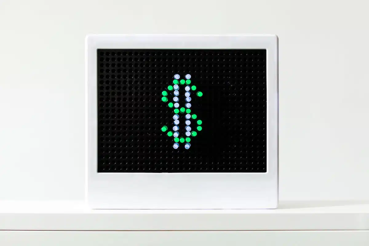 A landscape image of a small LED light with a green and white dollar sign.